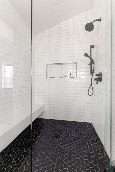 Give your bathroom a contemporary edge! Modern design with clean white subway tiles, a walk-in shower with dual showerheads in matte black, and contrasting dark hexagonal floor tiles make a powerful statement. Handy storage for shower essentials keeps it neat and tidy. A perfect blend of function and beauty! Save this for your next bathroom revamp. Black Hexagon Shower Floor, Modern Beach Bathroom, Hexagon Shower Tile, Hexagonal Floor Tiles, Hexagon Shower Floor, Contemporary Farmhouse Exterior, Modern Coastal Bathroom, White Subway Tile Shower, Bathroom Revamp