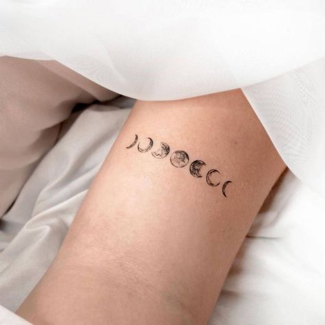 7 Moons Tattoo, Tiny Moon Phases Tattoo, Moon Phases Tattoo Back Of Neck, Moon Phases Tattoo Arm Band, Moon Phases Tattoo Line Work, Bicep Moon Tattoo, Moon Phase Ear Tattoo, Small Moon Phases Tattoo, Moon Phases Tattoo Thigh