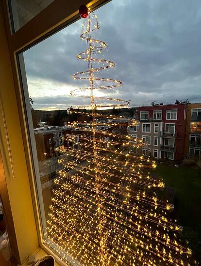 If you don't have the room for a regular Christmas tree or don't have the budget this year, then our DIY Wall Christmas Tree might be your perfect holiday solution. Obviously you can do this on a large window as well. Which is what we did! Made from firefly, or fairy lights (which are different from regular string lights) it’s pretty, space saving, inexpensive, and a real show stopper. You can use it as your main tree, or as a budget friendly way to add additional trees throughout the… Fairy Light Tree Indoor, Christmas Tree Window Lights, Fairy Light Wrapped Tree, Window Christmas Tree Ideas, Invisible Tree Christmas, Christmas Tree On Window, Christmas Tree Window Display, Christmas Tree On Wall With Lights, Christmas Tree Lights On Wall