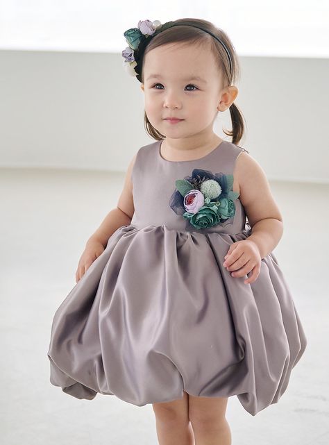 This balloon dress is made of a rich satin fabric in a shiny silver-gray color.   The flower corsage at the bust and voluminous balloon skirt create a feminine atmosphere.   The large corsage is decorated with fluffy feathers and elegant colored flowers for added glamour.    The skirt is made of three layers of lining, hard tulle, and satin, giving it great volume.   You can enjoy the fluffy volume without the need for separate panniers.   The back of the dress has Dressco's original laced design, giving it a luxurious feel like a wedding dress.   The lining is made of skin-friendly cotton, so it is comfortable to wear and even small children can wear it comfortably.  The color, shape, material and design of the corsage on the bust may change depending on when the material was obtained.  P Misty Flower, Children's Dresses, Balloon Skirt, Balloon Dress, Flower Corsage, Colored Flowers, Baby Dresses, Lace Design, Dress 100