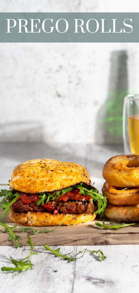 Prego steak roll on a wooden board with a side of onion rings. Prego Rolls, Prego Sauce Recipe, Cheese And Onion Pasty, Prego Sauce, Steak Rolls, Tender Steak, Portuguese Cuisine, Portuguese Food, Bread Roll