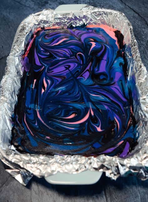 Galaxy Cheesecake Bars are cosmic cheesecakes that will light up your party! These tasty treats are made with delicious vanilla cheesecake with swirls of black, dark blue, pink, and purple. #cheesecakebars #galaxy #dessertrecipes Galaxy Themed Desserts, Galaxy Party Food, Galaxy Cheesecake, Galaxy Food, Floating Through Space, Galaxy Desserts, Gourmet Candy Apples, Gourmet Candy, Vanilla Cheesecake