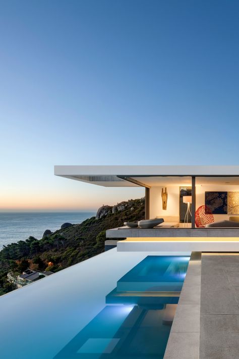 An infinity swimming pool and luxury villa overlooks the ocean at sunset. Villa With Infinity Pool, Cape Town Villa, Cape Town Mansions, Cape Town Beach House, Villa On The Beach, Luxury Spanish Villa, Dream Beach Houses Luxury, Cape Town Houses, Modern Beach Mansion