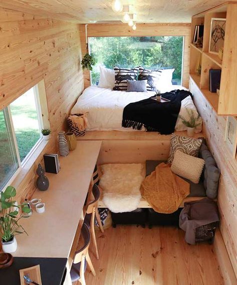 There is a lounging space and table with two chairs in front of the bed. Rustic Tiny House, House Design Ideas, Tiny House Inspiration, Casa Container, Floor Bed, Tiny House Interior, Tiny House Cabin, Tiny House Living, Diy Interior