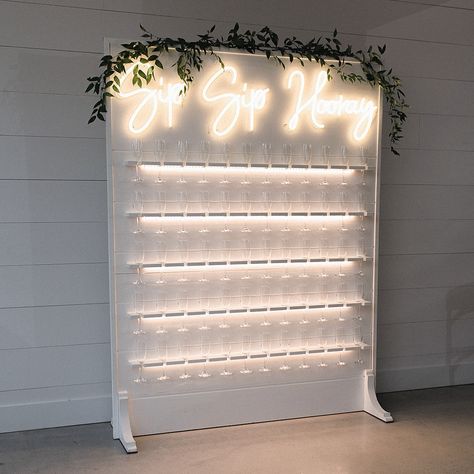 Light up white champagne wall Wedding champagne wall Champagne Flute Wall, Mini Champagne Wall, Champagne Wall Wedding Diy, How To Build A Champagne Wall, White Champagne Wall, Drink Wall Wedding, Grand Opening Party Ideas, Champagne Wall Ideas, Diy Champagne Wall