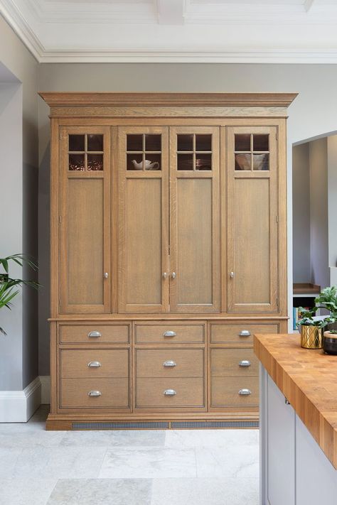 A bespoke traditional style kitchen dresser with a difference designed by Hetherington Newman!  With bi-fold doors and drawers in natural stained oak, the cabinet looks like a traditional dresser when closed but reveals a practical breakfast point inside when open complete with hot tap & microwave oven.

#kitchendresser #oakdresser #breakfastpoint Wooden Kitchen Dresser, Oak Kitchen Dresser, Amish Built Kitchen Cabinets, Hetherington Newman, English Pine Dresser, Amish Custom Kitchen Cabinets, Traditional Dresser, Kitchen Dressers, Dresser Kitchen