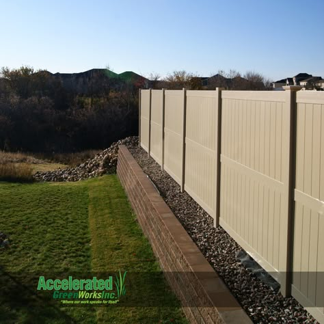 This is an 8'-0" tan vinyl privacy fence atop a short Versa-Lok retaining wall.  The neighbor on the left side has a drastically lower yard elevation than the neighbor on the right.  The retaining wall accommodates the elevation difference and the fence offers the privacy. Retaining Wall Between Neighbors, Retaining Wall Ideas Side Of House, Fence On Wall, Cheap Retaining Wall, Dog Proof Fence, Unique Fence Ideas, Steep Gardens, Wood Picket Fence, Vinyl Privacy Fence