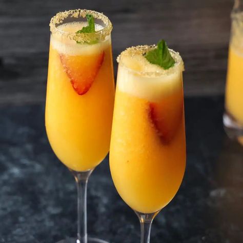 Easy Frozen Peach Bellinis • Flavor Feed Bookmark Icon, Frozen Peaches, Peach Vodka, Brunch Drinks, Mixed Drinks Alcohol, Peach Bellini, Alcoholic Beverage, Strawberry Slice, Perfect Brunch