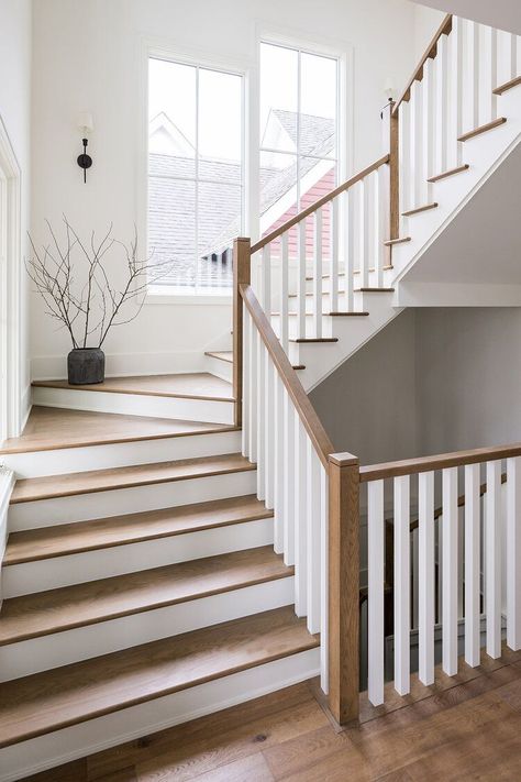 A gorgeous staircase is illuminated by large windows and rich wood. + staircase design + wood staircase + white spindles + grand staircase | Design By: aaNovo Wooden Staircase Design, Transitional Staircase, White Staircase, Staircase Designs, Wooden Staircase, White Stairs, Staircase Railing Design, House Staircase, Wood Railing