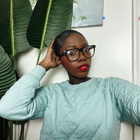 Black woman wearing glasses in a slick low bun with a blue sweater wearing red lip stick Red Lipstick And Black Lip Liner, Brown Lip Liner With Red Lipstick Black Women, Red Lipstick With Black Liner, Red Lipstick Black Lipliner, Black Lined Red Lips, Lipstick For Dark Skin, Lip Liner, Makeup Inspo, Trend Setter