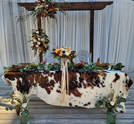 Cowhide Sweetheart Table, Western Table Runners Rustic, Cow Print Wedding Ideas, Cowhide Head Table Wedding, Bride And Groom Table Western, Western Wedding Sweetheart Table, Cowhide Wedding Table, Western Sweetheart Table Wedding, Western Wedding Head Table Ideas