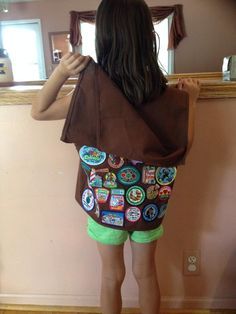 How to handle too many fun patches on a Girl Scout vest: create a cape using a second vest (clip the front flaps off, and sew the top to the top of the back of the original vest). Clever! Girl Scout Badge Placement, Girl Scout Brownie Vest, Uniform Tips, Brownie Vest, Girl Scout Daisies, Girl Scout Vest, Girl Scout Sash, Girl Scout Gifts, Girl Scout Shirts