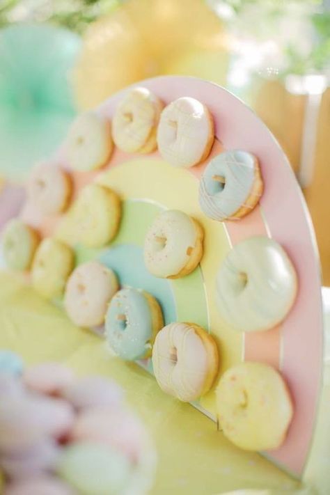 Another great donut suggestion is a pastel rainbow donut wall. You can place it on your dessert table so your guests can help themselves. Make sure each donut is a different color and you can't really go wrong.See more party ideas and share yours at CatchMyParty.com Rainbow Donuts Ideas, Pastel Baby Birthday Party, Pastel Rainbow Gender Reveal Party, Pastel Rainbow Birthday Party Decorations, Pastel Rainbow Baby Shower Ideas, Pastel Themed Birthday Party Decorations, Pastel First Birthday Party, Pastel Rainbow Birthday Party, Easter Garden Party