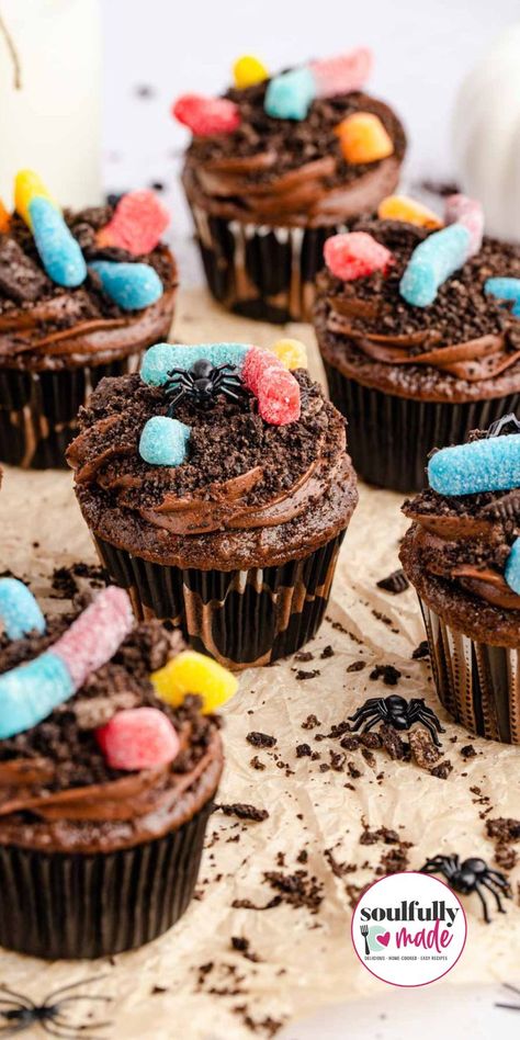 A table full of decorated dirt gummy worm cupcakes and spiders. Halloween Birthday Party Cupcakes, Dirt Worm Cupcakes, Gummy Worm Cupcakes, Bug Themed Treats, Bug Themed Cupcakes, Bug Cupcakes For Kids, Bug Party Cake, Insect Theme Birthday Party, Insect Cupcakes