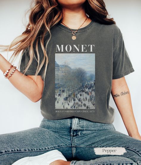 ✿ Unisex Monet T-Shirt ✿ Introducing our t-shirt adorned with Claude Monet's iconic masterpiece, "Boulevard des Capucines." For the passionate art lover, this wearable canvas captures the bustling energy and vibrant atmosphere of Parisian life in the late 19th century. With its delicate reflections this t-shirt embodies the ethereal allure of impressionist art making it a perfect gift for art teachers and art lovers. T-SHIRT DETAILS We use COMFORT COLORS for our T-shirts: High Quality, SUPER sof Artistic Relaxed Fit T-shirt With Custom Artwork, Artistic Crew Neck T-shirt With Printing, Artistic Printed Crew Neck T-shirt, Artistic T-shirt With Custom Artwork, Relaxed Fit, Monet Tshirt, Boulevard Des Capucines, Art Teacher Gifts, Monet Art, Paris T Shirt