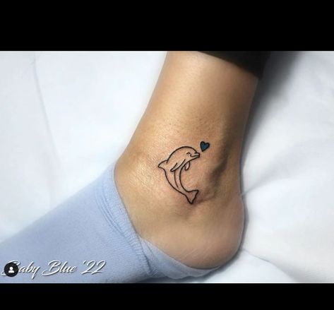 The dolphin tattoo represents love and peace, as shown by the blue heart in this tattoo. The dolphin is friendlier, and its bright smile and excellent performance are constant reminders of children laughing. It is a charming tattoo representing love,... Small Dolphin Tattoo Designs, Dolphin Tattoo For Women Small, Dolphin Heart Tattoo, Dolphin Tattoo For Women, Small Dolphin Tattoo, Tattoo Dolphin, Memorial Tattoos Mom, Charming Tattoo, Children Laughing