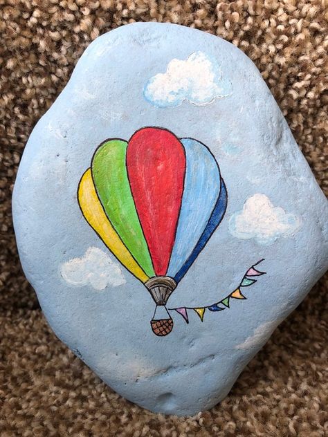 So graceful is this colorful hot air balloon floating across the cloud filled blue sky.  Measures 5 1/2“ x 4 1/2“ x 1“ Art Coquillage, Balloon Painting, Rock Painting Tutorial, Paint Rocks, Stone Art Painting, Painted Rocks Kids, Rock Painting Ideas, Painted Rocks Craft, Painted Rocks Diy