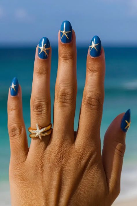 Hand with blue nail polish featuring starfish designs, adorned with starfish rings, against a beach backdrop. Starfish Nail Art, Starfish Nails, Beachy Nail Designs, Fish Nail Art, Starfish Colors, Fish Nails, Seashell Nails, Starfish Art, Beachy Nails