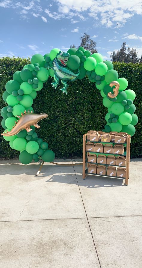 Green dinosaur balloon garland Dinosaur Balloon Decorations, Jurassic Park Balloon Arch, Dino Backdrop Birthday Party Ideas, Dinosaur Backdrop Ideas, Dinosaur Balloon Arch, Dinasour Ballon Decoration, Dino Theme Birthday Party Backdrop, Jurrasic Park Balloon Decor, Dinosaur Balloon Garland