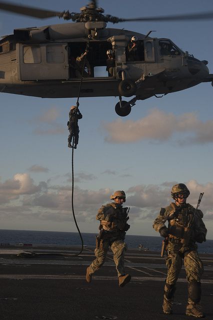 CORAL SEA (July 19, 2013) Sailors assigned to Explosive Ordnance Disposal Mobile Unit (EODMU) 5 drop from an MH-60S Seahawk from the "Golden Falcons" of Helicopter Sea Combat Squadron (HSC) 12 onto the flight deck of the USS George Washington (CVN 73) during a fast rope exercise in support of Talisman Saber (TS) 2013. The TS exercise is a biennial training event aimed at improving Australian Defense Force (ADF) and US combat readiness and interoperability as a Combined JTF. Wojskowy Humor, Rope Exercise, Jet Fighter Pilot, Military Aesthetic, Army Images, F1 Wallpaper Hd, Airplane Fighter, Army Pics, Coral Sea