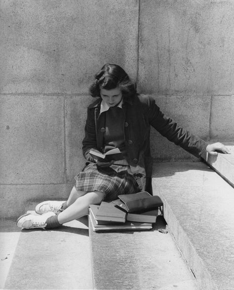 Student, dressed for class, reading on steps, 1950s.“I am reading six books at once, the only way of reading; since, as you will agree, one book is only a single unaccompanied note, and to get the full sound, one needs ten others at the same time.” ― Virginia Woolf, The Letters of Virginia Woolf: Volume Three, 1923-1928 Foto Portrait, Black And White Photograph, Woman Sitting, Lukisan Cat Air, Foto Vintage, Woman Reading, Reading A Book, Girl Reading, 인물 사진