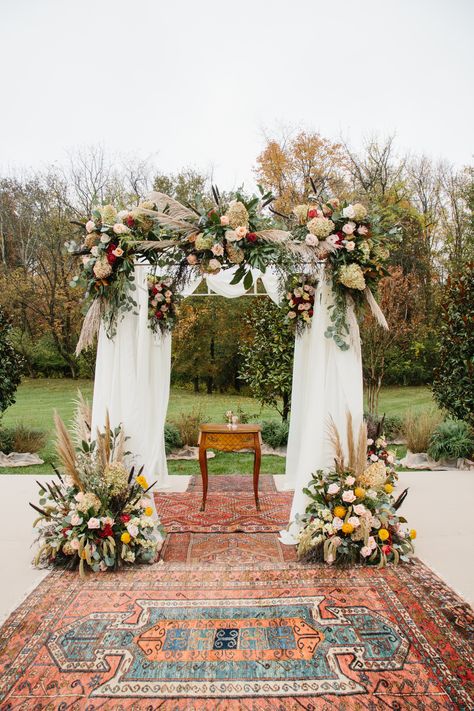 Bohemian inspired fall florals and antique rugs framing this gorgeous wedding chuppah at this intimate, backyard wedding. Rug Altar Wedding, Fall Wedding Chuppah, Boho Chuppah, Wedding Rugs, Huppah Wedding Fall, Fall Chuppah, Wedding Altar Rug, Fall Wedding Flowers Chuppah, Chuppah Ideas