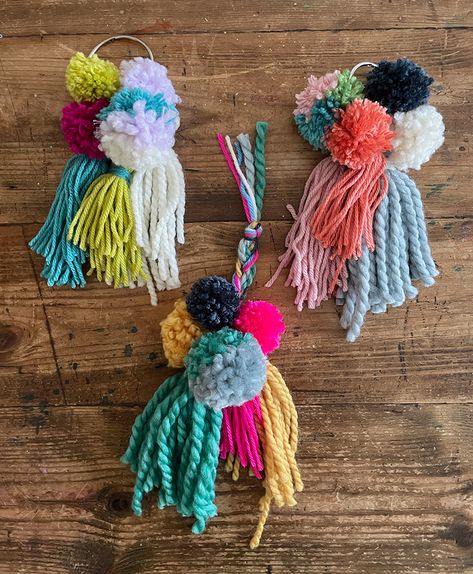 3 finished pom-pom tassel hangers on a table in different color schemes Tassel Pom Pom, Tassel Diy, Pom Pom Mobile, Diy Pom Poms, Big Yarn, How To Make A Pom Pom, Pom Pom Maker, Pom Pom Crafts, Diy Tassel