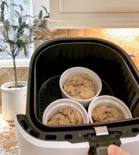 placing ramekins filled with pre-made chocolate chip cookie dough into the air fryer Pazookie In Ramekin, Airfry Cookie Dough, Ramekin Chocolate Chip Cookie, Cookie Ramekin, Air Fryer Ramekin Desserts, Air Fried Cookie Dough, Air Fryer Ramekin Recipes, Cookie Dough In Air Fryer, Nestle Cookie Dough