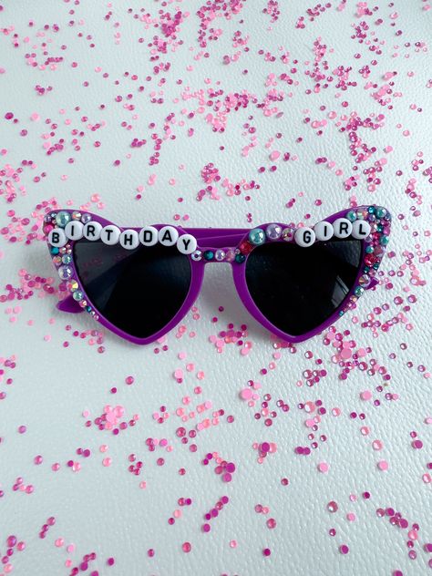 This listing is for one pair of bespoke heart sunglasses embellished by hand. Personalized sunnies are perfect gifts for moms, daughters, graduates, and brides, and are great for festivals, concerts, birthday parties, and team pride! PLEASE NOTE: This item is made by hand, which means that embellishments may vary from the image. I use a combination of high quality glass rhinestones and resin flat-back pearls, along with other eclectic embellishments like flowers, butterflies, and snakes. Due to Birthday Heart, Sunglasses For Kids, Gifts For Moms, Personalized Gifts For Kids, Gold Text, Heart Sunglasses, Kids Sunglasses, Letter Beads, Rhinestone Designs