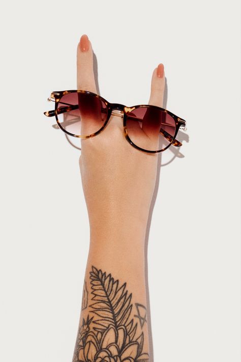 Retro Glam: Oversized Gold Sunglasses Graced by Inked Hands. A Fashion Statement with Attitude, Style, and Individuality. Vintage Chic Meets Contemporary Edge - Tattooed Arm Holds Iconic Shades. Bold Accessories for the Bold You. Expressive Fashion Fusion - Retro Gold and Tattooed Skin Eyewear Photography, Eyewear Trends, Bold Accessories, Gold Sunglasses, Classic Frame, Eyewear Fashion, Model Photography, Photography Inspo, Vintage Chic