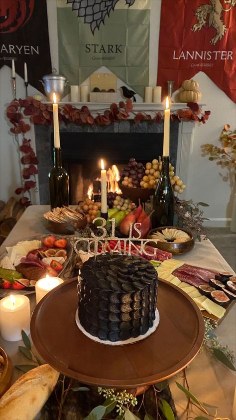 Game of Thrones Birthday Theme Party. I threw my own 31st birthday party and decided on GOT. I custom ordered this dragon scale cake and etsy ordered the cake topping that reads "31 is coming". Did a great food theme of a whole chicken roast, sour breads and cheese platter. Drank red wine and lit candles. Also had the fireplace going with GOT episodes playing in the background. Game Of Thrones Birthday Decorations, Game Of Thrones Themed Food, House Of Dragons Party, Game Of Thrones Party Food, Game Of Thrones Themed Party, Game Of Thrones Food Ideas, House Of The Dragon Watch Party, Game Of Thrones Party Ideas, Game Of Thrones Birthday Party Ideas