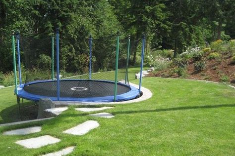 Fortunately, there are still ways you can safely do this, so let's take a quick look at how to set up a trampoline on a slope. Trampoline Uneven Ground, Trampoline Play Area, Sunken Backyard Patio, How To Make A Trampoline Look Nice, Gravel Under Trampoline, Trampoline On Sloped Yard, Sloped Backyard Landscaping On A Budget, Sloping Garden Ideas On A Budget, Trampoline Ideas Landscapes