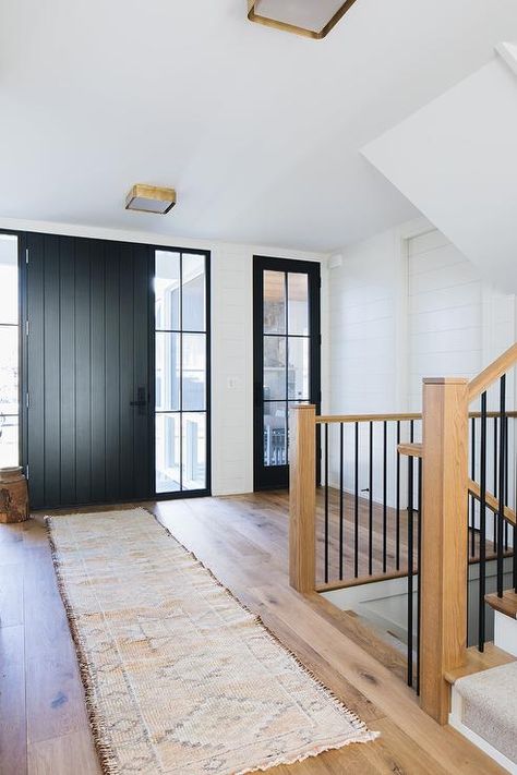 Kate Marker Interiors - Stoffer Photography - A black plank front door flanked by sidelights opens to a foyer boasting a pink vintage runner placed on a wide plank wood floor. Plank Door, Rustic Wood Floors, Kate Marker Interiors, Door Design Photos, Black Front Doors, Cliff House, Wood Floors Wide Plank, Entrance Foyer, Foyer Design