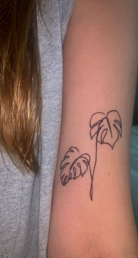 a one line drawing tattoo of a split leaf philodendron, a plant that bears leaves with unique slits and holes naturally occurring in the leaves Mini Monstera Plant Tattoo, Line Work Plant Tattoo, One Line Plant Tattoo, Simple Monstera Tattoo, Line Art Tattoos Simple, Body Line Tattoo, Simple Plant Tattoo, Plant Tattoos For Women, Simple Line Art Tattoo