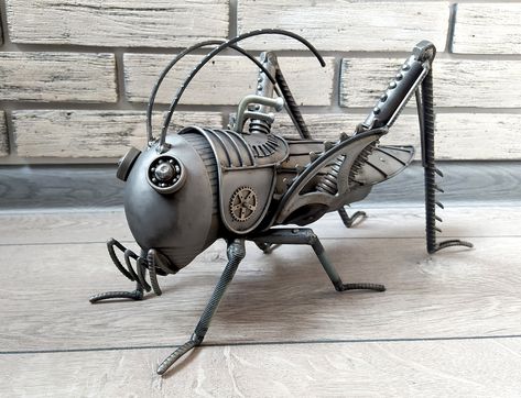 Steampunk Grasshopper sculpture. Metal sculpture art. Made of metal. IIt is 35 cm long, 18.5cm width and 22.5 cm height (13.77 Inch - long, 7.08 Inch - width, 8.66 Inch - height). Art Metal sculpture Steampunk Grasshopper, Grasshopper sculpture. Metal Grasshopper figurine. Metal Grasshopper, statuette Grasshopper Steampunk Insect This particular metal sculpture steampunk Grasshopper steampunk is made entirely out of metal materials. Its very simple but intriguing to look at. Using grinding and w Assemblage Art Sculpture, Steampunk Robot, Stag Beetle, Metal Fish, Art Metal, Metal Art Sculpture, Arte Robot, Metal Garden Art, Metal Art Projects