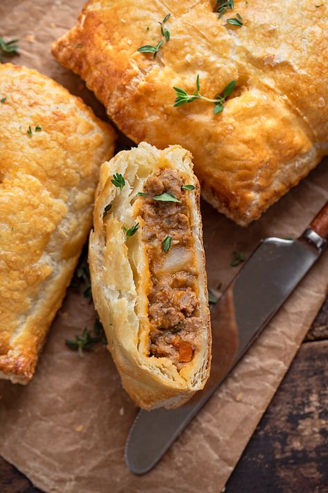 Hot and flaky, these savory hand pies are brimming with a rich, saucy filling of ground beef, diced potatoes, veggies and fresh thyme! | thecozyapron.com #savoryhandpies #savoryhandpiesrecipes #savoryhandpieseasy #savoryhandpiesmeat #savoryhandpieswithpremadepiecrust Shepherds Pie Hand Pies, Ground Beef Hand Pies Puff Pastries, Hand Held Meat Pie Recipe, Sausage Hand Pies, Ground Turkey Hand Pies, Handheld Meat Pies, English Hand Pies, Savory Turnover Recipes, Handheld Pies Savory