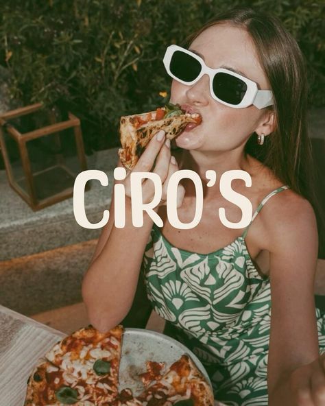 Young woman in white sunglasses and green floral top eating pizza outdoors with modern vintage restaurant branding overlay showing Ciro's logo Cafe Aesthetics, Retro Italian, Sidewalk Cafe, Nostalgic Vibes, Retro Cafe, Restaurant Branding Design, Cafe Branding, Food Branding, Retro Recipes