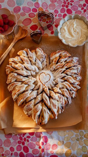 Sarah Reed on Instagram: "This tear-apart cinnamon roll heart (or Tearin’ Up My Heart, as I like to call it 🎶) will be the perfect addition to your Valentine’s or Galentine’s Day breakfast or brunch! 💘 (Of course it can be a snack or dessert if you’d prefer.) I made this with my favorite cinnamon roll dough by @ambitiouskitchen, but you could definitely make this using puff pastry if you want a shortcut! The heart is smaller than my cinnamon roll snowflake, with only two layers. It’s a bit easier and not as huge as the snowflake. It’s got two layers of dough and I topped it with a light layer of cream cheese frosting and of course, a dusting of powdered sugar to make it extra pretty. I’d say the hardest part was rolling the dough out into heart shapes. You could always cut it, but I didn Cinnamon Roll Hearts Valentines Day, Heart Puff Pastry Valentines Day, Heart Shaped Pastry, Cinnamon Tear Apart Bread Heart, Heart Shaped Deserts, Pretty Puff Pastry, Tearing Up My Heart Cinnamon Roll, Valentine’s Day Cinnamon Rolls, Valentine Cinnamon Rolls