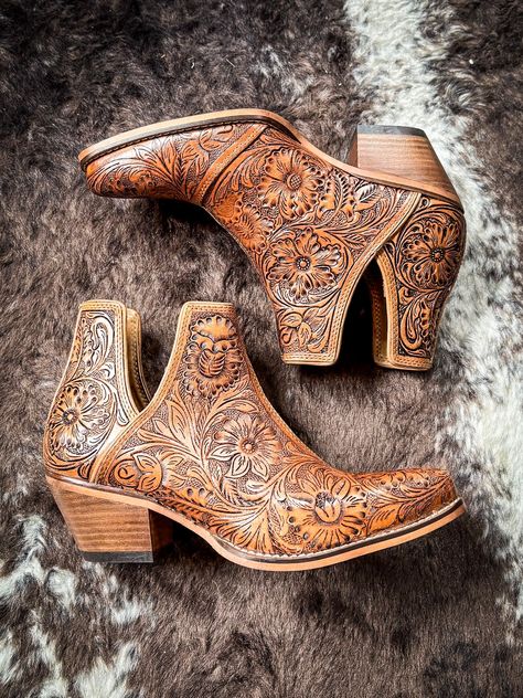 Step into the epitome of Southwestern flair with these Western leather booties, meticulously hand-tooled to highlight a stunning blend of rich bourbon hues. Featuring classic cowboy heels and convenient side slits, they blend traditional craftsmanship with modern ease. The intricate design, showcasing a pattern of desert blossoms, adds a distinctive touch of elegance. Ideal for transforming any ensemble, these tooled boots exude statement-making style with every step. 2" slanted heel. 6-11 not a Tooled Boots, Cowboy Heels, Hay Bag, Classic Cowboy, Pick Your Poison, Wrap Boots, Horse Boots, Western Leather, Purse Strap