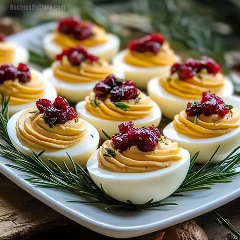 A festive take on deviled eggs with creamy yolk filling, cranberry sweetness, and a hint of smoked paprika. Flavored Deviled Eggs, Deviled Eggs With Bacon Jam, Hot Chili Deviled Eggs, Christmas Deviled Eggs Recipe Best, Xmas Deviled Eggs, Elevated Deviled Eggs, Christmas Deviled Eggs Ideas, Deviled Eggs Christmas, Curry Deviled Eggs Recipe