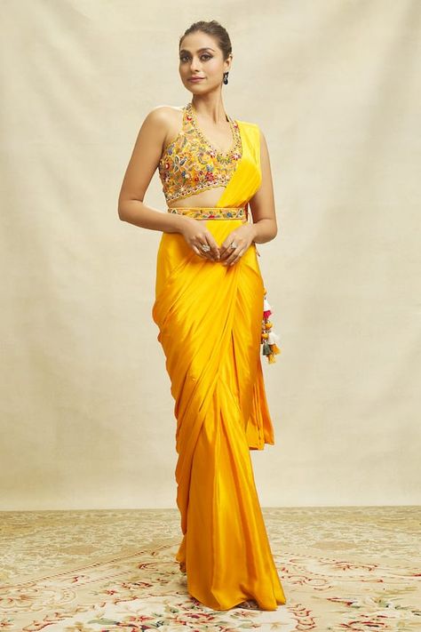 Yellow plain saree with side tie-up tassel details crafted in crepe. Paired with a sleeveless floral embroidered padded blouse and floral embroidered belt. Components: 3 Pattern: Embroidered Type Of Work: Floral Neckline: Halter Sleeve Type: Sleeveless Fabric: Crepe Color: Yellow Occasion: Mehendi and Haldi - Aza Fashions Saree Gowns, Chiffon Embroidery, Cotton Sarees Handloom, Stitched Saree, Simple Saree Designs, Plain Saree, Royalty Aesthetic, Simple Sarees, Drape Saree