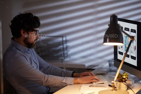 Man working on computer by AnnaStills. Serious young man sitting at the table in front of computer monitor and typing on computer keyboard till evening at o... #AD #AnnaStills, #young, #man, #Man Person Sitting In Front Of Computer, Typing On Computer Pose Reference, Sitting At Computer Reference, Man Working On Computer, Typing On Computer, Computer Pics, Laptop Photography, Working On Computer, Sitting At Desk