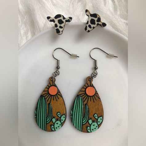 Two Pairs Of Statement Costume Jewelry Earrings. One Pair Of Drop/Dangle Wooden Earrings With A Cactus And Sun Design. Silver Tone Hardware. One Pair Of Cow-Print Wooden Stud Earrings. Western Vibes. Super Cute! A Great Gift For A Country Friend!Message Me And I’ll Wrap It Nicely And Include A Personalized Note! New/Never Used Or Worn. Have A Nice Day! Wood Burnt Earrings, Wood Burned Earrings, Cow Print Earrings, Hair Earrings, Earrings Western, Western Vibes, Wood Earring, Sale Ideas, Sun Design