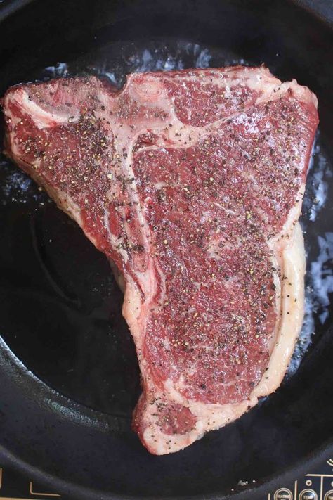 Overhead view of cooking a seasoned t-bone steak in a hot cast iron skillet with sizzling all around Cast Iron Steak Recipes, T Bone Steak Recipe In Oven, Tbone Steak In Oven, Best T Bone Steak Recipe, Iron Steak Recipes, Cast Iron Steak Oven, Bourbon Cream Sauce, Cooking T Bone Steak, Steak Recipes Pan