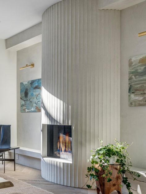 A Fluted Fireplace Surround Is A Central Feature In The Living Room Of This House In New York Curved Fireplace Surround, Curved Fireplace Wall, Fluted Fireplace Surround, Feature Fireplace Wall, Fluted Fireplace, Fireplace Architecture, Fluted Marble, Curved Fireplace, Steel Frame Doors