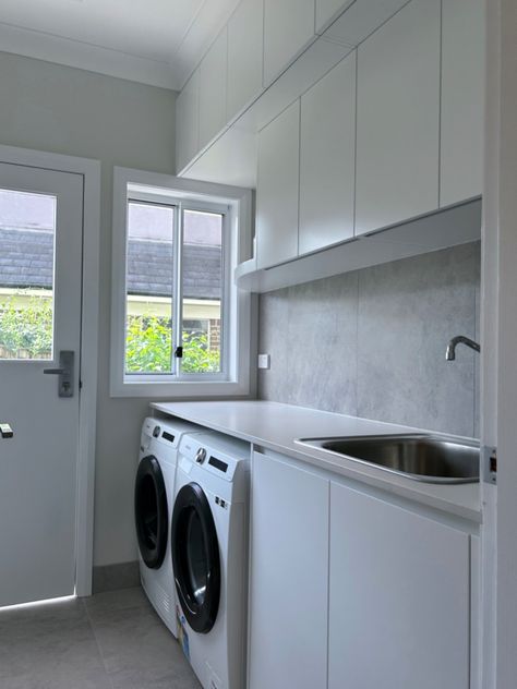 Custom designed and manufactured laundry, featuring a 20mm stone bench top, 'flat' profile doors, finished in a white satin polyurethane and tiled stone splashback. #kitchensbyemanuel #kbecastlehill #laundry #laundryideas #laundrygoals #laundryinspo #customdesignedlaundry #customlaundry #sydney #local #custombuiltlaundry Laundry Feature Tile, Laundry Splashback Ideas, Laundry Tiles Backsplash, Laundry Backsplash Ideas, Stone Splashback, Laundry Splashback, Laundry Idea, Laundry Reno, Stone Benchtop