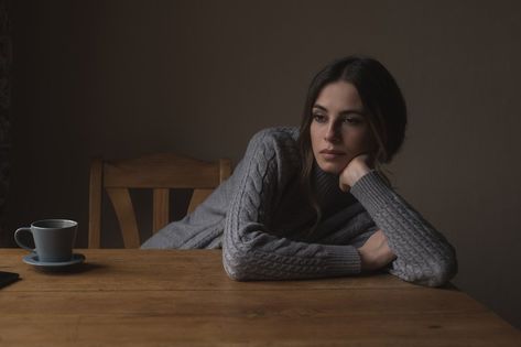 Thoughtful woman leaning on table against wall at home Person Laying On Table Reference, Door Lean Pose, Leaning On Arm Reference, Leaning On Elbows Pose, Leaning Forward Reference, Elbow On Table Pose Reference, Head Leaning On Hand Reference, Bored Reference, Head On Table Pose