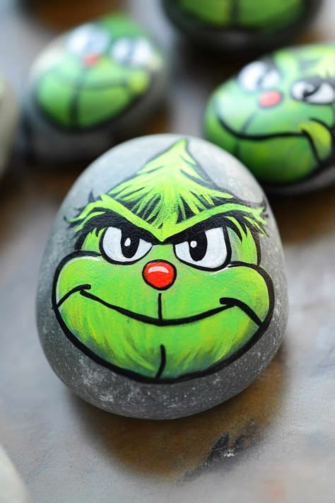 Colorful painted rock depicting the Grinch with a Santa hat, surrounded by festive decorations. What Paint To Use On Rocks, Grinch Rocks Painted, Christmas Rock Painting Ideas Easy, Grinch Designs, Christmas Rock Painting Ideas, Christmas Rock Painting, Stone Paintings, Christmas Rocks, Christmas Rock