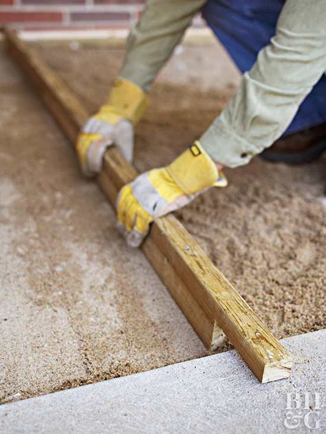 For the second layer of support, spread 1-1/2 to 2 inches of builder's sand over the gravel. Lay a long, straight board along the base of the house. Then take another board, notch both ends, and shimmy it along the walk and the other board to smooth the sand. Flagstone Pavers, Pavers Diy, Diy Patio Pavers, Paver Designs, Patio Pavers Design, Patio Pavers, Paver Walkway, Flagstone Patio, Brick Pavers