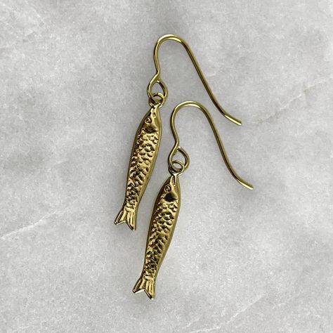 A fish symbolizes fertility, feelings, creativity, rebirth, good luck, transformation, health, abundance, serenity, intelligence, happiness, strength, and endurance. Connecting us with the water element, it represents the deeper awareness of the unconsciousness or higher self.  Gold plated solid 925 sterling silver or 925 sterling silver fish hook earrings. Fish measures 2cm in length. Material : Sterling Silver, 24k Gold Plate. Each piece is handmade to order in the Jewel Thief Brighton atelier Sardine Earrings, Pisces Earrings, Birthday 21st, Silversmithing Jewelry, Mothers Day Present, Birthday Gold, Fish Jewelry, Fish Hook Earrings, Mothers Day Presents